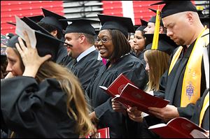 Shannon Take of South Toledo, center, beams as she and her fellow graduates take their places at the start of commencement at Owens Community College.