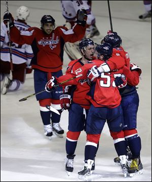 Washington Capitals defenseman Mike Green, second from right, is congratulated by teammates after he scored the game-winning goal in overtime.