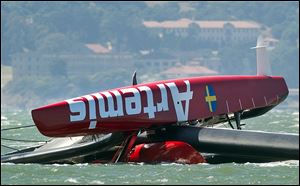 The Artemis Racing AC72 catamaran, an America's Cup entry from Sweden, lies capsized after flipping over during training in San Francisco Bay.