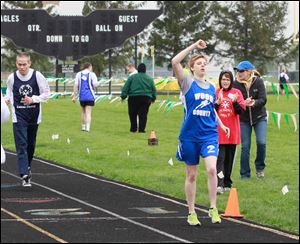 800-meter gold medalist Amanda Gump of Wayne crosses the finish line before Edmund Lyons of Toledo at the Special Olympics Ohio Area 4 competition at Oregon’s Clay High School.     