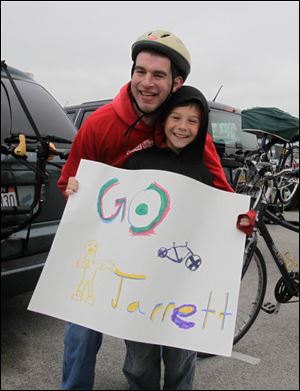 Bicyclist Jarrett Brann, left, of Oregon gets support from Xander Shiffert, 9, of Curtice, Ohio. About 600 athletes competed in the games Saturday.