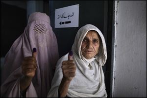 Pakistani women show their election ink-stained thumbs after casting their ballots at a polling station today on the outskirts of Islamabad, Pakistan.