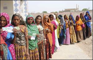 Pakistani women line up outside a polling station waiting to cast their ballots today in Hyderabad, Pakistan.