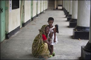 A Bangladeshi woman reacts holding her son's daughter after her son's body was found after the April 24 garment factory building collapse in Savar, near Dhaka, Bangladesh.