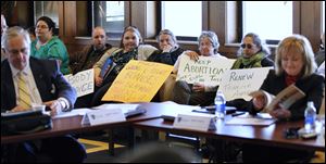 Protesters attend the University of Toledo Board of Trustees meeting today to protest the school's decision to end transfer agreements with local abortion clinics and cuts to students services.