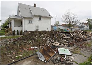 Neighbors on East Broadway in East Toledo say they have waited too long for a pile of debris to be cleaned up and taken away.