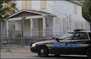 A Cleveland police patrol car sits in front of the boarded up home of Ariel Castro in Cleveland today.