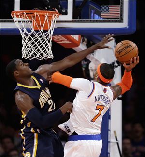 New York Knicks' Carmelo Anthony, right, goes up for a shot against Indiana Pacers' Paul George in the first half of Game 5.