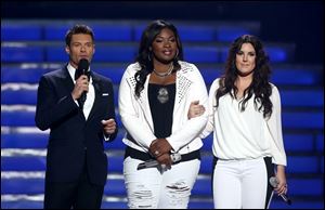 Host Ryan Seacrest, left, and finalists Candice Glover, center, and Kree Harrison speak on stage at the 'American Idol' finale Thursday night.