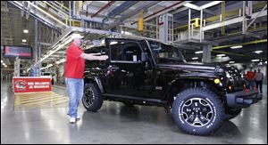 Dan Henneman, Jeep unit chairman of UAW Local 12, gets out of the one-millionth Jeep Wrangler JK model that rolls off the assembly line at Chrysler Toledo Assembly Complex.