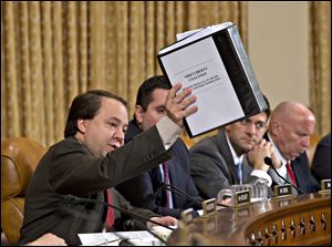 House Ways and Means Committee member  Rep. Pat Tiberi, R-Ohio, left, holds up a binder with documents about a constituent's application to the IRS that was delayed.