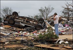 John Warner surveys the damage near a friend's mobile home in the Steelman Estates Mobile Home Park, destroyed in Sunday's tornado, near Shawnee, Okla..