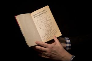 Sotheby's director of the department of printed books and manuscripts Philip Errington poses for photographers with a first edition copy of the first Harry Potter book 