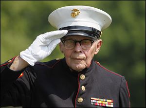 Marine Corporal Bob Romaker, 86, salutes.