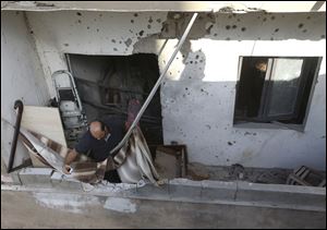 A Lebanese investigator takes pictures at a balcony where a rocket struck an apartment in a building at Chiyah district, south of Beirut, Lebanon, today.