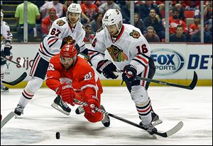 Detroit Red Wings defenseman Carlo Colaiacovo (28) tries to clear the puck from Chicago Blackhawks center Marcus Kruger (16), during the first period in Game 6.