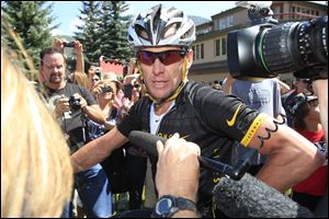 Lance Armstrong talks to reporters after his second-place finish in the Power of Four mountain bicycle race at the base of Aspen Mountain in Aspen, Colo., in 2012.