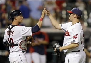 Cleveland Indians catcher Yan Gomes, left, and relief pitcher Matt Albers celebrate the Indians' 7-1 win over the Cincinnati Reds.