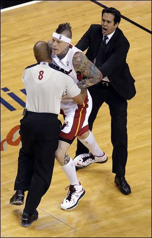 Official Marc Davis (8) and Miami Heat coach Erik Spoelstra restrain Heat's Chris Andersen during the first half.