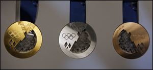 Gold, left, silver, center, and bronze medals are displayed for journalists during a presentation of Sochi 2014 Olympic medals at the SportAccord International Convention today in St. Petersburg, Russia.