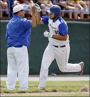 Northwood’s Justin Rohrs is congratulated by coach Dave Russell after the first of his two home runs against  Delphos St. Johns.