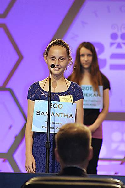 Samantha-Schofield-stands-on-stage-as-she-spells-the-word