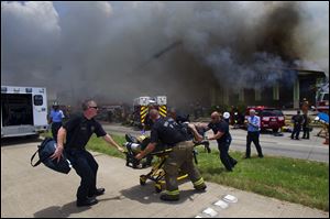 A firefighter is wheeled to an ambulance after fighting a fire at the Southwest Inn, Friday in Houston. A fire that engulfed a motel killed four firefighters.