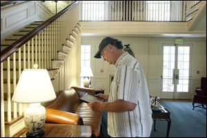 Visitor John Borton looks at a historical photograph during a recent tour of the Manor House at Wildwood Preserve Metropark. 