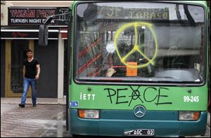 A man walks next to a destroyed bus after clashes at Taksim Square in Istanbul. Some Turks believe Prime Minister Recep Tayyip Erdogan has threatened the foundation of the traditionally secular democracy.