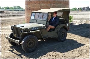 Vittorio Argento sits in an original Willys MB (Jeep) that he brought from Italy to the Willys-Overland factory site in Toledo. The vehicle was built on the site in 1943.  One of the original smokestacks from the factory still stands on the site.