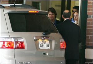 Shannon Richardson, right, is led from the emergency room at CHRISTUS St. Michael Health System in Texarkana, Texas.