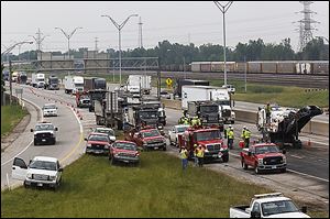 Crews repair asphalt that was damaged by spilled diesel fuel and a fire after two tractor-trailers collided on northbound I-75 in North Toledo.