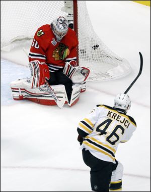 Chicago Blackhawks goalie Corey Crawford (50) makes a save on a shot by Boston Bruins center David Krejci (46) during the first period.