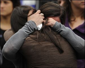 Carlee Soto, front, and Jillian Soto, sisters of slain teacher Victoria Soto, embrace during a ceremony on the six-month anniversary honoring the 20 children and six adults gunned down at Sandy Hook Elementary School.