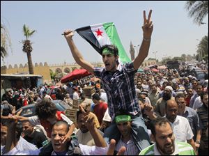 Egyptian Salafis shout slogans against Syrian President Bashar Assad as one waves a Syrian revolutionary flag during a rally after the Friday prayers at Amr Ibn Al As mosque, in Cairo, Egypt.