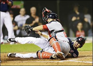 The Indians' Drew Stubbs, right, scores while the Nationals' Kurt Suzuki tries to make the play in the ninth inning.