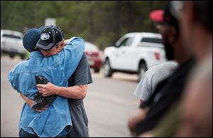 Ray Miller, left, hugs his wife Cindy before he heads into the burn zone with a police escort Friday to try to retrieve medication from their home that was burned to the ground in the Black Forest fire near Colorado Springs, Colo. 