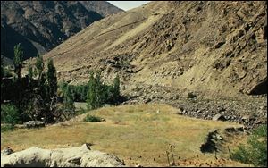 India and Pakistan come face to face in hostile posture in Kashmir. The small grassy knoll in the middle is no man's land. The famous Lasa-Skardu trail is half-way up the mountain on the right.