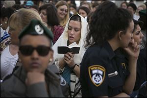 An Israeli Jewish woman of the Women of the Wall organization prays while wearing a prayer shawl at the Western Wall.