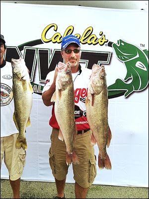 Kevin O'Malley of Pennsylvania shows off two of the five walleye he caught on the first day of the Cabela's National Walleye Tour event on Lake Erie.