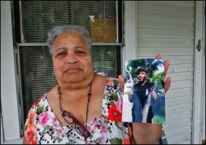 Linda Watson holds a photo of her nephew Frederick D. Watson, Jr., who was found shot to death in a car early Sunday morning.