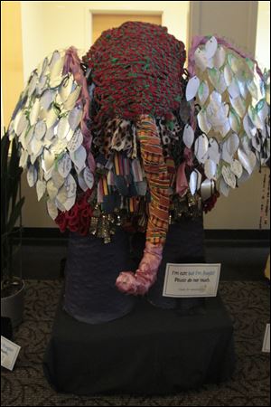 Strips of cotton T-shirts, paper, pieces of alumi-num, and other recyclable materials cover the chicken wire skeletons of the three elephants that currently guard the main entrance of the Bedford Branch of the Monroe County Library System.