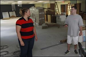 Erin Curley, an architecture designer at Architecture by Design, explains the progress of the construction of the new wing to Richard Velandra, who is helping out at the Sylvania Area Family Services.