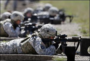 Female soldiers, shown here, may be able to begin training as Army Rangers by mid-2015, and as Navy SEALs a year later.