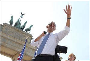 President Obama  waves to spectators before he  delivers a speech in front of the Brandenburg Gate  at Pariser Platz in Berlin, Germany, today.