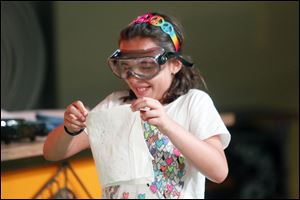 Audrey Elchert, 10, who is visiting from Minnesota, reacts to being sprayed with germs from a sneeze during a 30-minute program to children about the things the body produces.