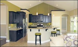 Dark maple cabinets are hung at varying heights for visual interest and topped by granite.