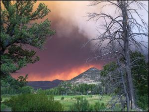 In this photo provided by the U.S. Forest Service, wildfires fires approach the town of South Fork, Colo. Thursday.