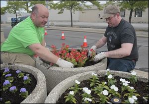 Volunteers Craig Jablonski, left, and Kory Meinhart plant begonias on Monroe Street.