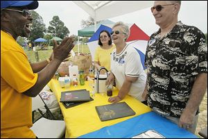 From left, William Ellis, Theresa Moore Isaacs, her sister Kathy Moore Keyser, and Kathy’s husband, Dennis Keyser, all of Toledo, share a laugh at Saturday’s reunion for Libbey High School alumni. Mr. Ellis and the Keysers are members of the class of 1968; Ms. Isaacs is a member of the class of 1970.